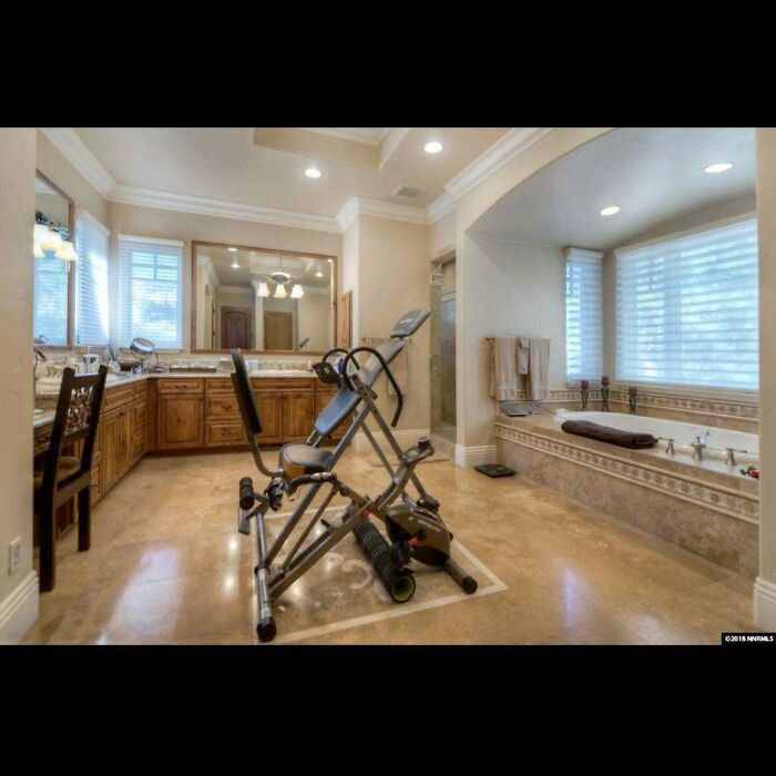 Exercise equipment oddly placed in a spacious bathroom showcases one of many home design disasters lacking both function and aesthetic appeal.