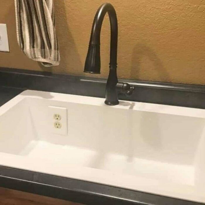 Kitchen sink with an electrical outlet installed inside the basin, a clear example of a home design disaster.