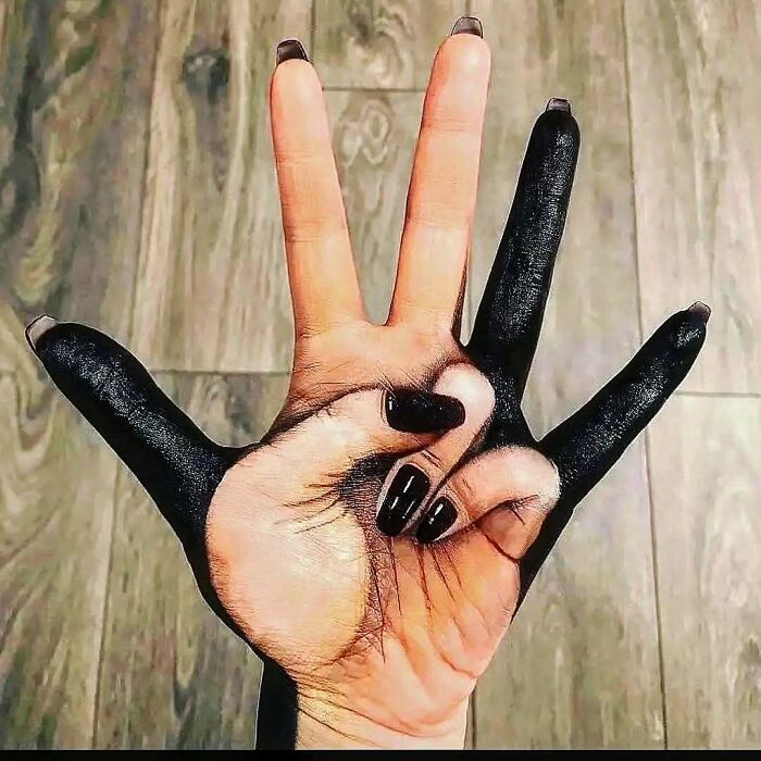 Hand with black ink painted fingers showing an ink fail that turned a bad idea into a permanent regret.