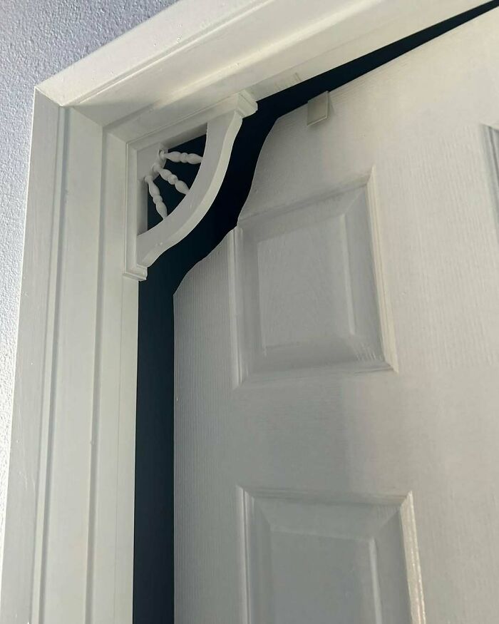 Door with a home design disaster showing an obstructed decorative wooden frame that affects door function.