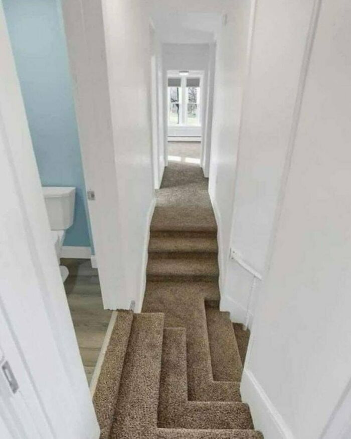 Narrow hallway with confusing carpeted staircase design illustrating home design disasters and poor aesthetics.