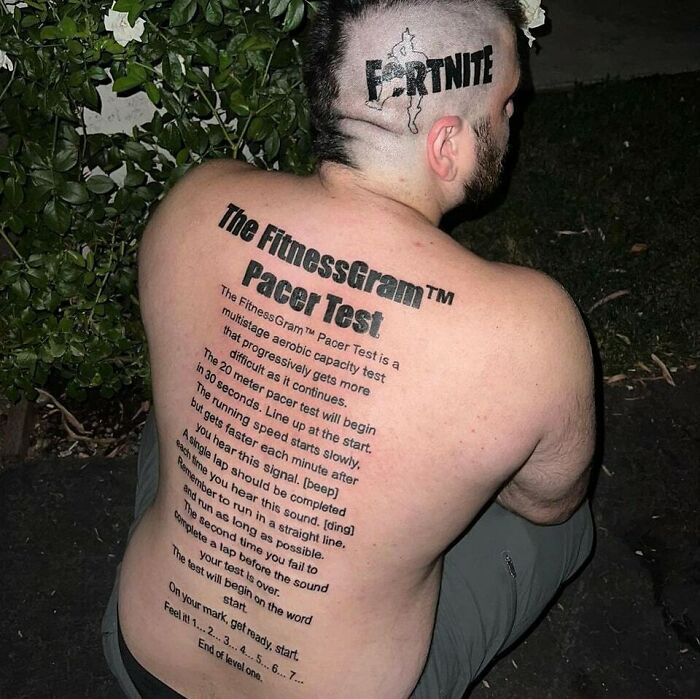 Man with large back tattoo of FitnessGram Pacer Test text and Fortnite logo tattooed on side of head, ink fail example.