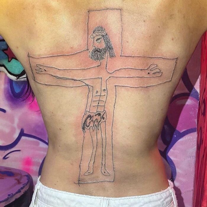 Back tattoo with a crude, failed ink design of a crucifixion, highlighting ink fails and bad ideas turned permanent regrets.