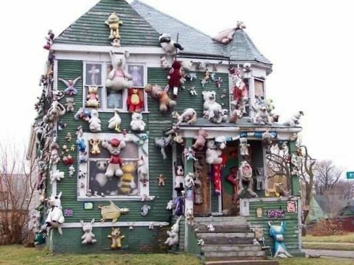A green house covered with numerous stuffed animals hanging on walls and windows showing home design disasters.