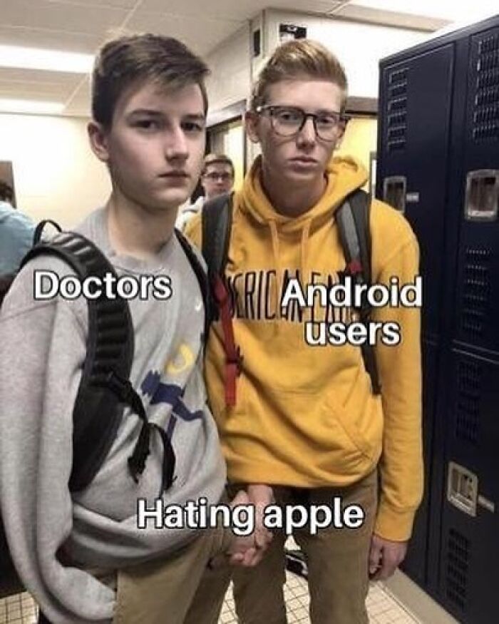 Two young men labeled doctors and Android users holding hands with caption expressing mutual dislike for Apple, a meme for doctors.
