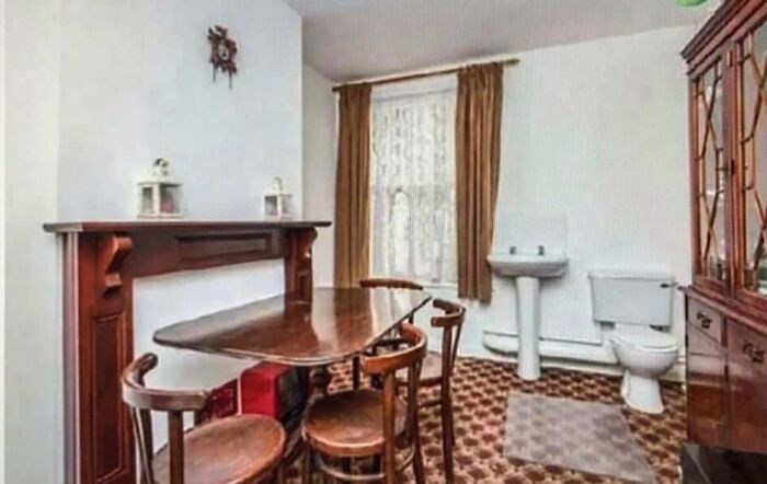 Dining area with table and chairs awkwardly placed near bathroom fixtures, a clear home design disaster lacking aesthetic appeal.