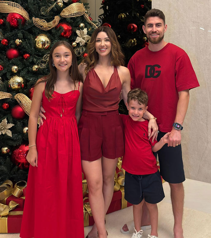 Family dressed in red standing by a decorated Christmas tree amid fans furious with Chappell Roan over security guard identity. Family dressed in red standing by a decorated Christmas tree amid fans furious with Chappell Roan over security guard identity.