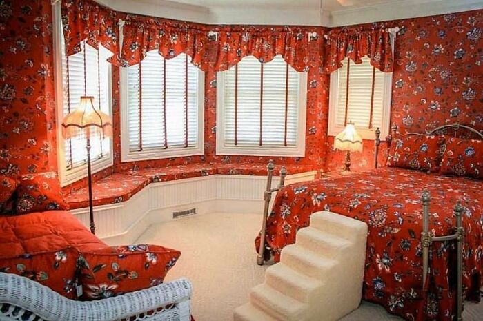 Bedroom with matching floral curtains, bedspread, and walls in a home design disaster lacking aesthetic appeal.