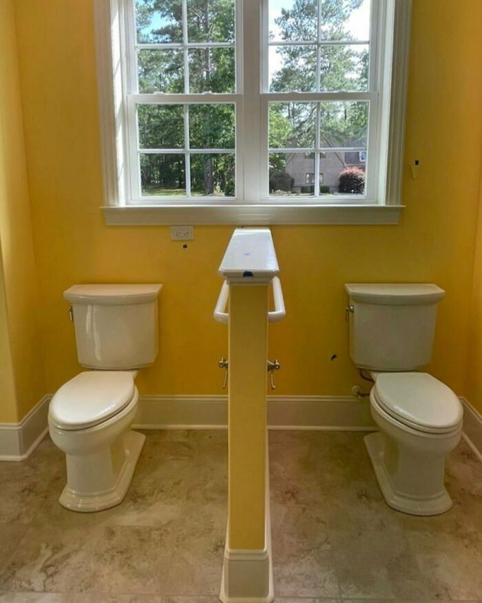 Two toilets separated by a narrow wall in a small bathroom, showcasing a home design disaster with poor layout.