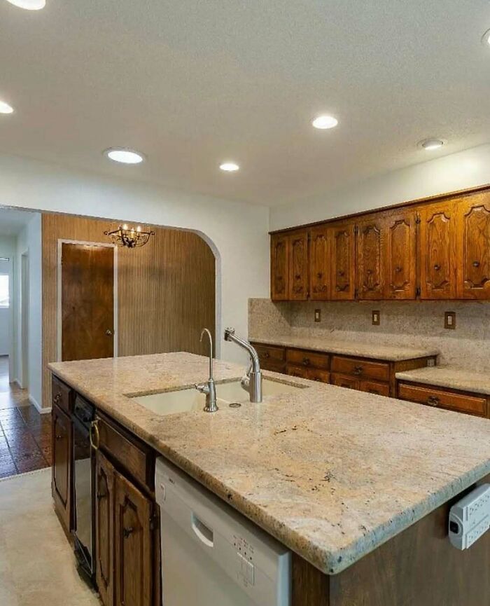 Kitchen island with sink and faucet lacking a functional backsplash, showcasing a home design disaster and poor aesthetics.
