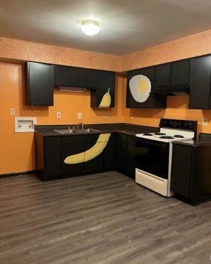 Kitchen with black cabinets painted with uncoordinated banana and egg designs, showcasing home design disasters.