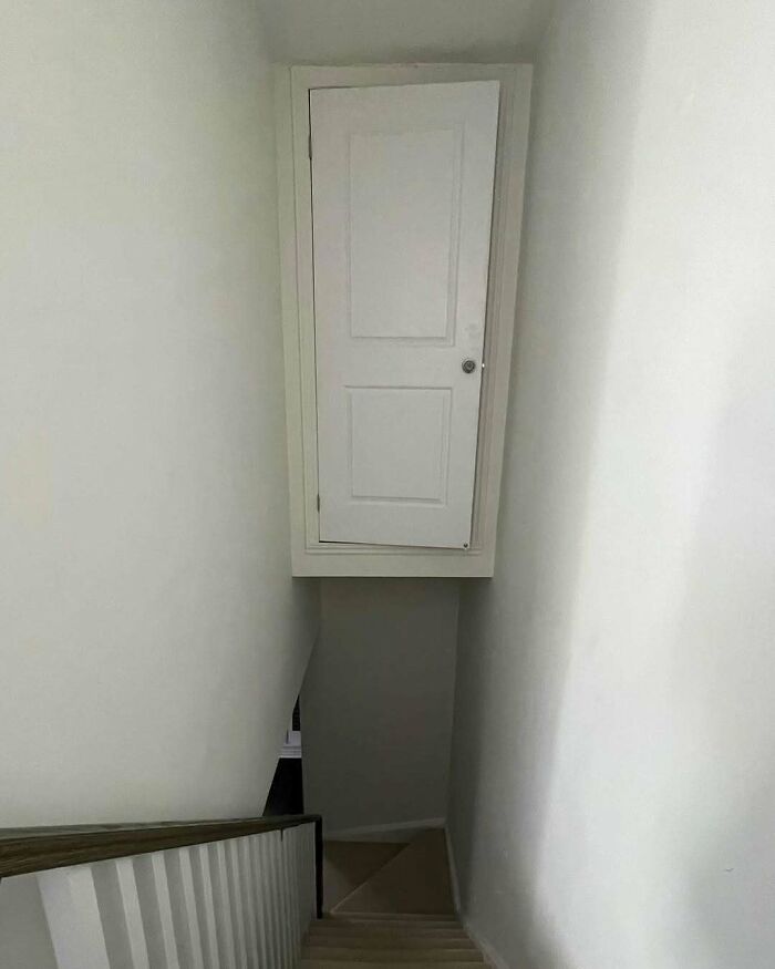 Closet door installed in a narrow stairwell blocking access, a clear home design disaster and poor aesthetic choice.