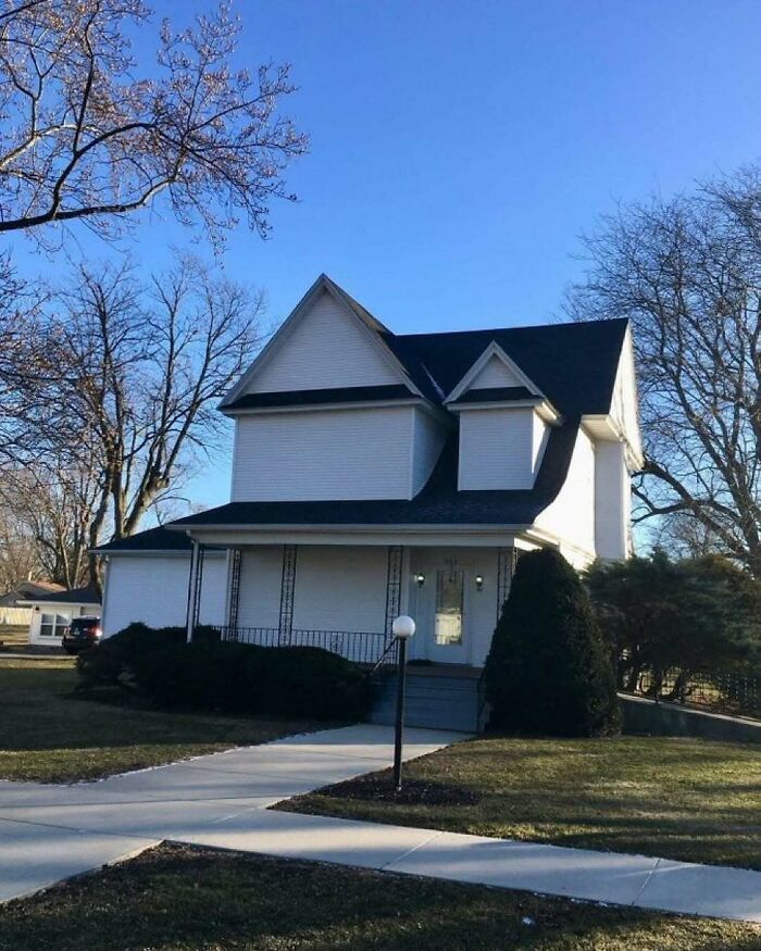 House with unusual and confusing home design disasters featuring misaligned roof and awkward architecture under clear blue sky.
