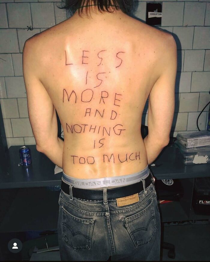 Person's back with poorly done tattoo reading less is more and nothing is too much, showing an ink fail regret.
