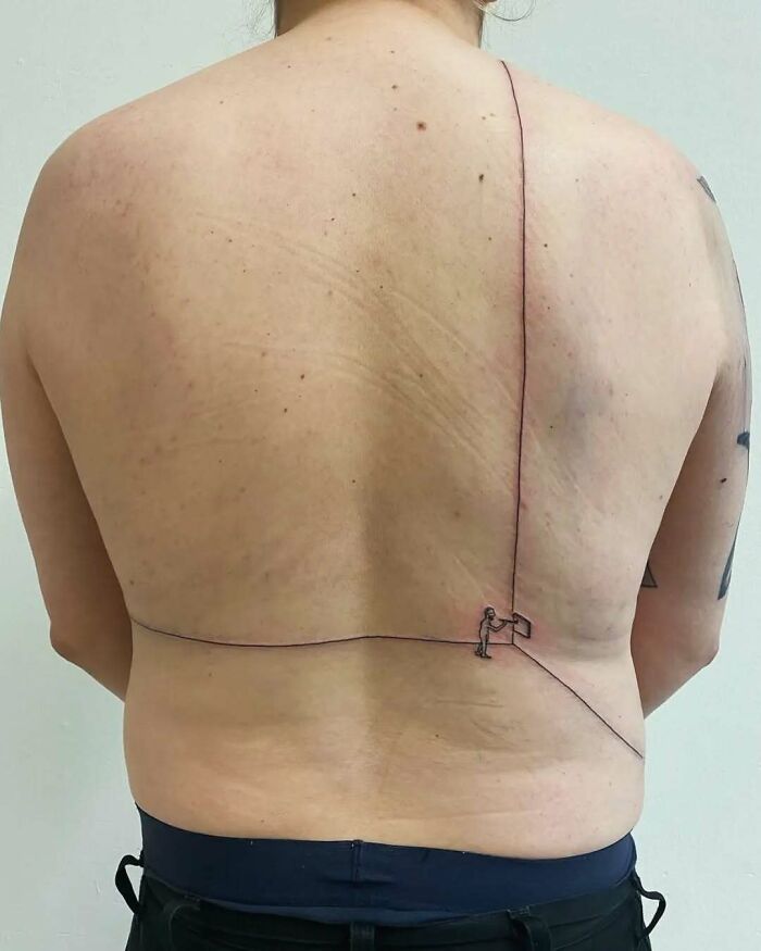 Minimalist back tattoo with thin ink lines and a small figure, showcasing one of the ink fails that turned into a permanent regret.