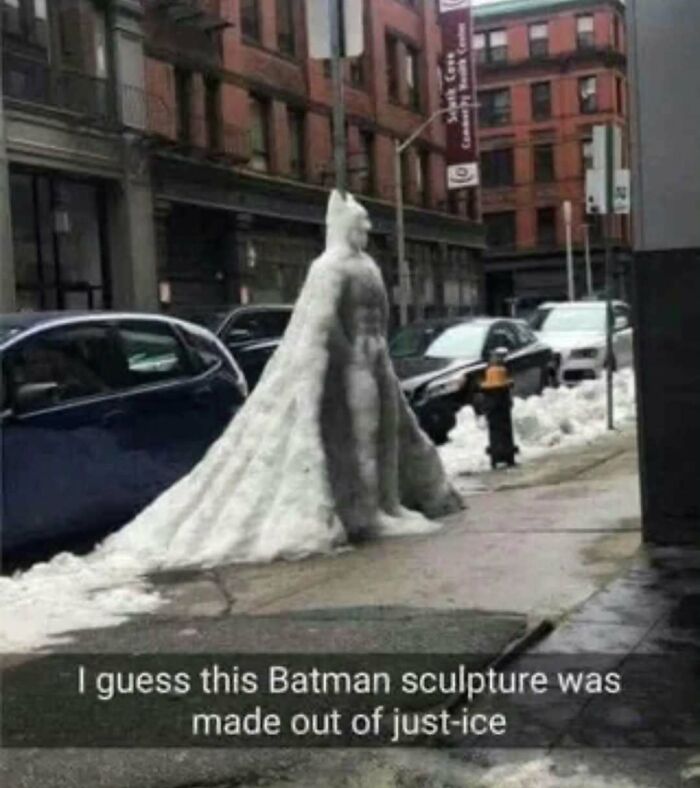 Snow sculpture of Batman on city sidewalk, featured in memes for those who need memes to function properly.