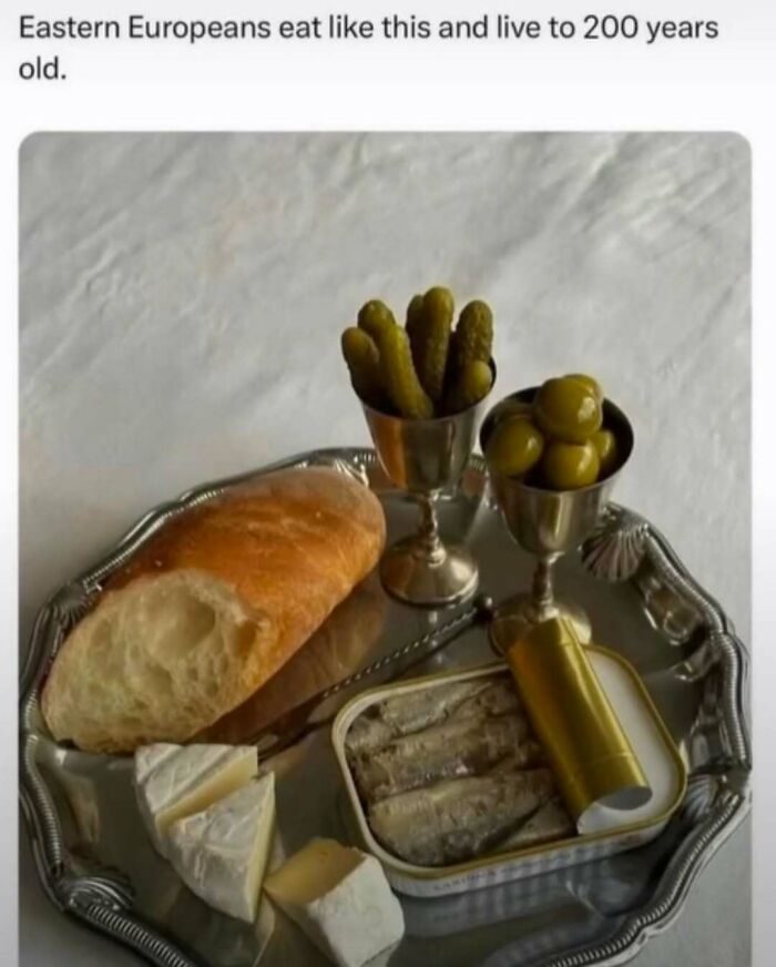 Silver tray with bread, cheese, pickles, olives, and canned fish illustrating food and eating memes.