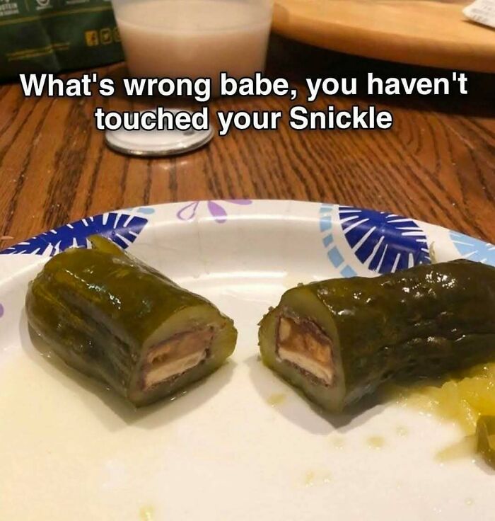 Pickle stuffed with a chocolate candy bar on a plate, humorous food meme for food lovers and eating enthusiasts.