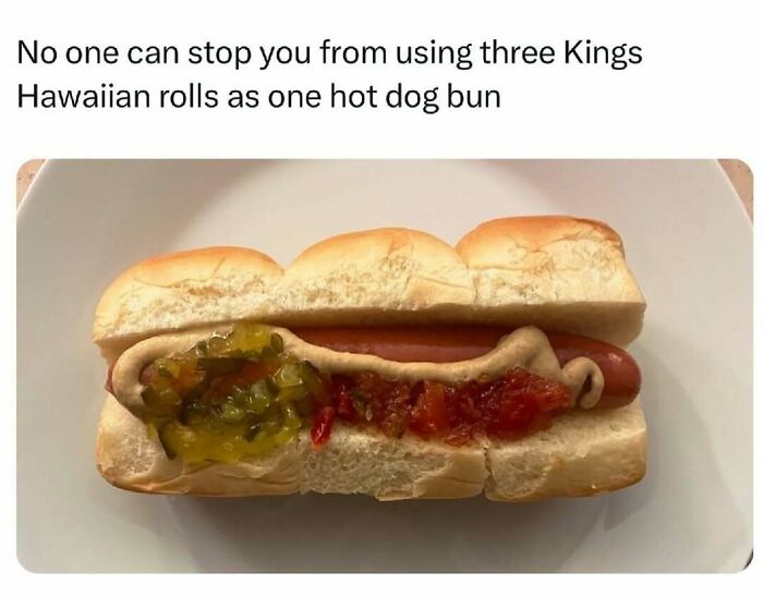 Hot dog with three Hawaiian rolls as bun topped with mustard, relish, and ketchup in a food meme about eating.