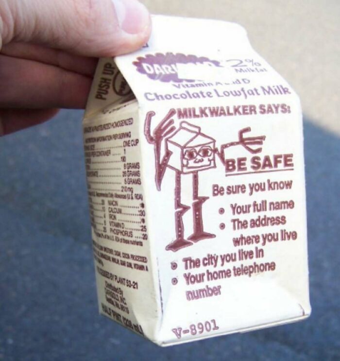 Hand holding a small milk carton with a drawing of a skeleton character and safety instructions in a cursed photo.