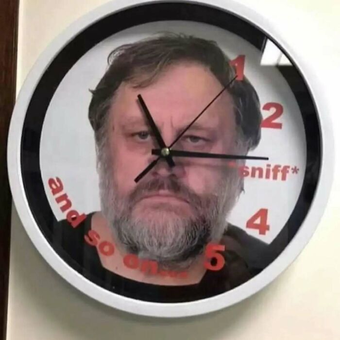 Clock with a serious bearded man's face and red text humorously overlaying time, reflecting existential crisis memes.