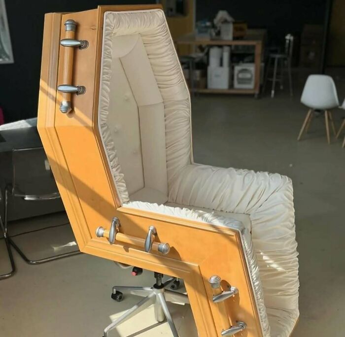 Armchair designed like a coffin with cushioned interior and metal handles, a cursed photo that confuses the brain.