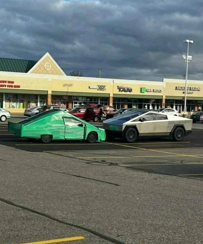 Two unusual cars, one homemade green and one Tesla Cybertruck, parked side by side in a cursed photo that defies logic.
