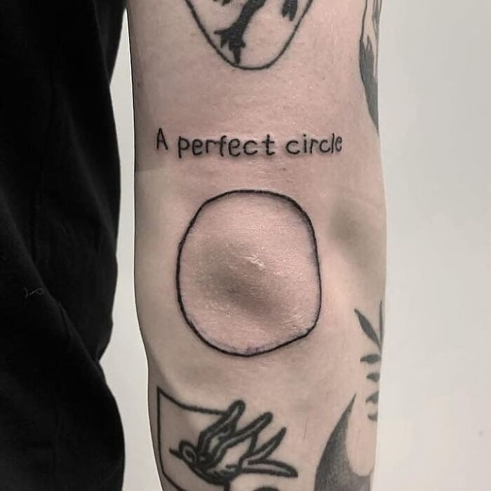 Tattoo of a misshapen circle labeled as a perfect circle, showcasing an ink fail and a regrettable tattoo mistake.