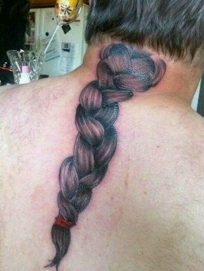 Tattoo ink fail of a braided hair tattoo on a man's neck and upper back, showcasing a permanent regret from a bad idea.