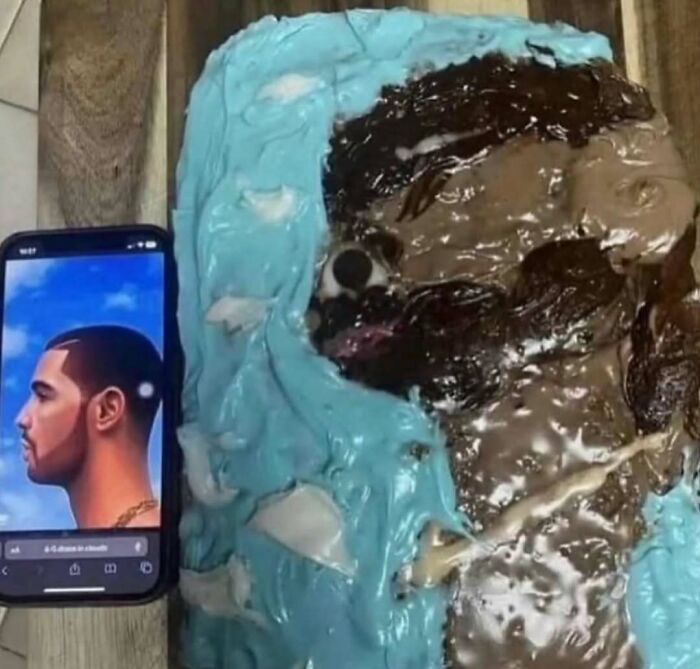 Phone displaying a portrait of Drake next to a poorly made cake attempting to replicate the same image, a cursed photo.