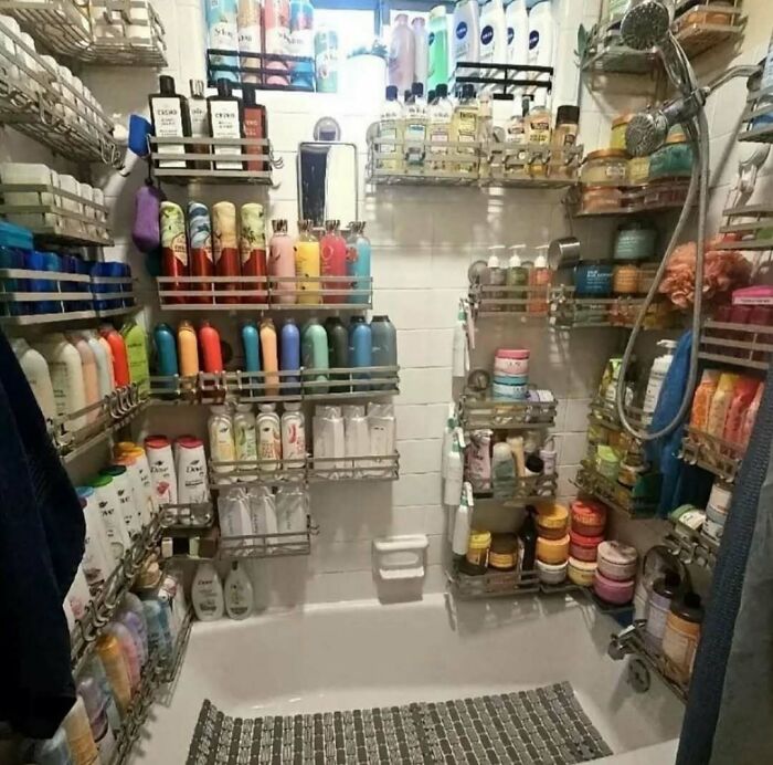 Bathroom shower filled with an overwhelming number of personal care products creating a cursed photo scene.