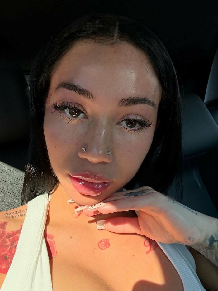 Close-up of a woman with facial piercings and tattoos, showcasing luxury lifestyle vibes related to custom mobile mansion trends.