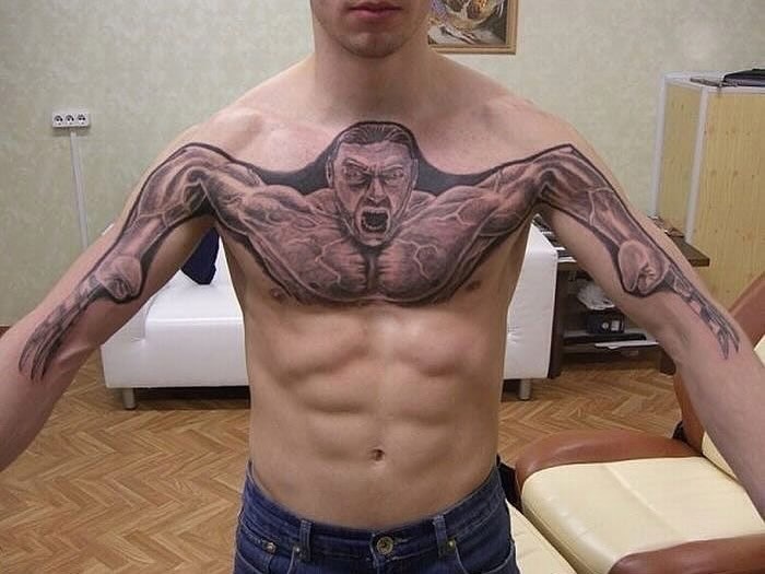 Man showing a chest and arm tattoo fail with distorted muscular figure, illustrating ink fails and bad tattoo ideas.