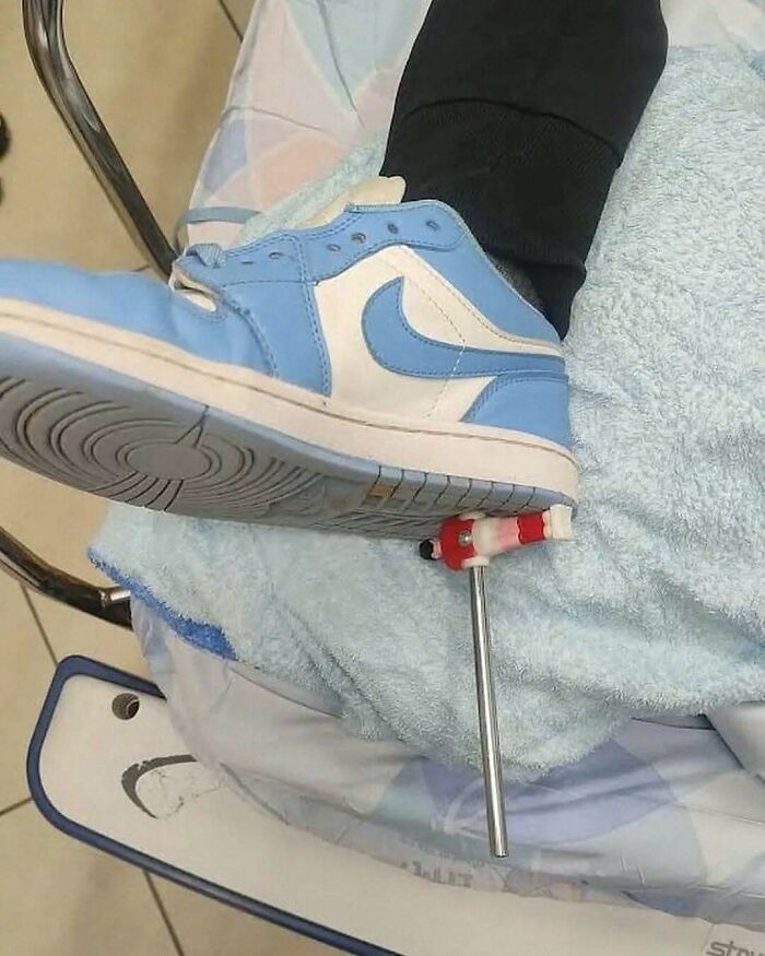 Blue and white sneaker with metal medical device attached to leg, shown on a light blue towel in clinical setting.