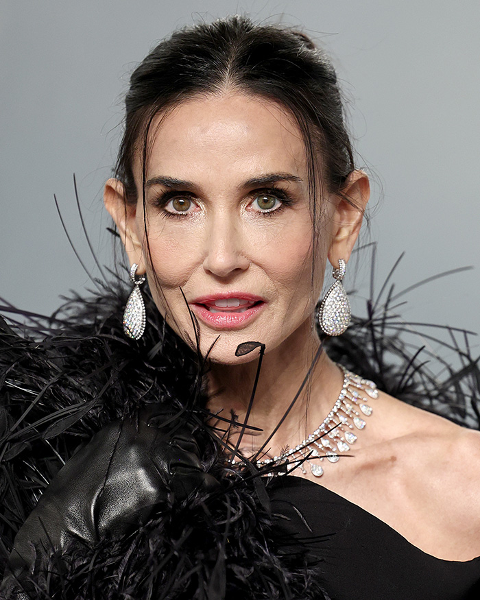 Close-up of a star at the Oscars after-party showing unfiltered skin under unforgiving lighting and sparkling jewelry.