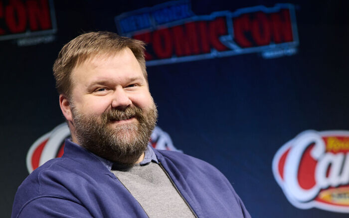 Bearded man smiling at a Comic Con event, related to discussions about Tom Cruise turning down Invincible Season 4.