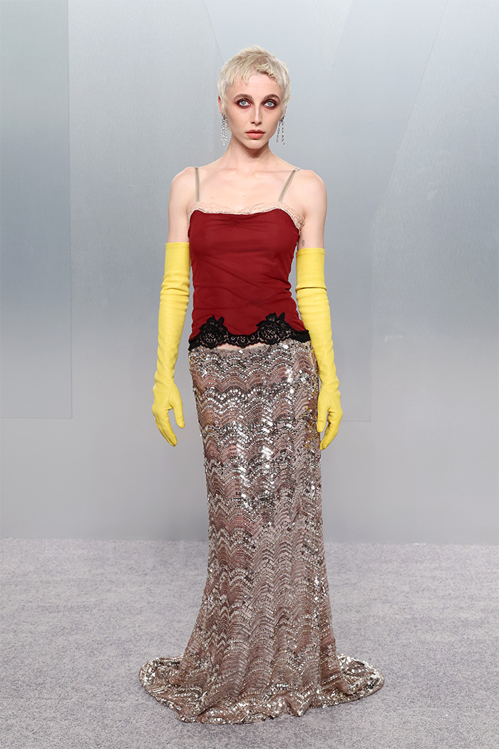 Model wearing a bold mismatched outfit with yellow gloves and a sequined skirt at Oscars afterparties fashion fails event.