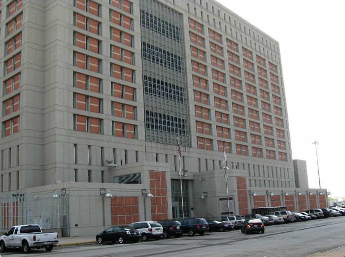 Large urban courthouse exterior with parked cars, relating to infamous luxury real estate brothers human trafficking case.