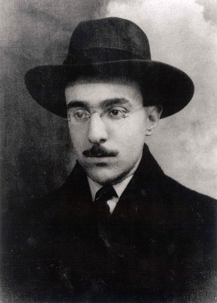 Black and white historical photo of a man wearing glasses and a hat, notable figure who likely passed away a virgin.