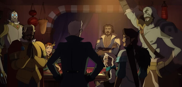 The Legend of Vox Machina characters gathered around a table in a dimly lit animated fantasy setting.