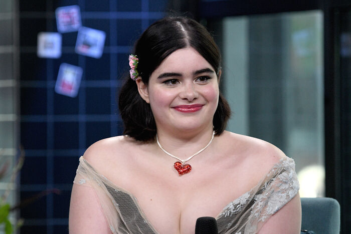 Barbie Ferreira with dark hair and a heart necklace appearing at an event, sparking debate over her transformation.