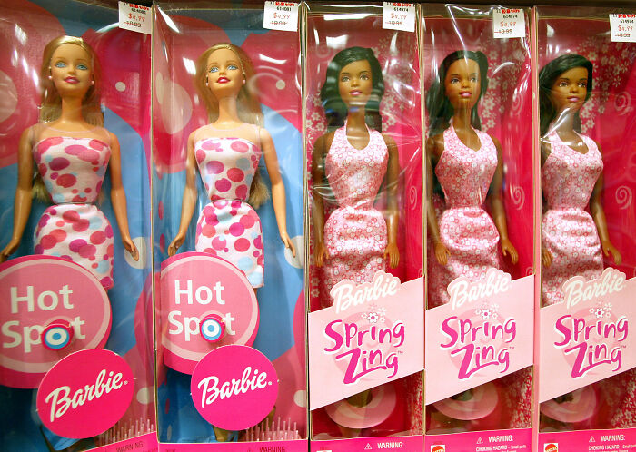 Barbie dolls in pink dresses displayed in packaging, related to Barbie Dream Fest and guest reactions.