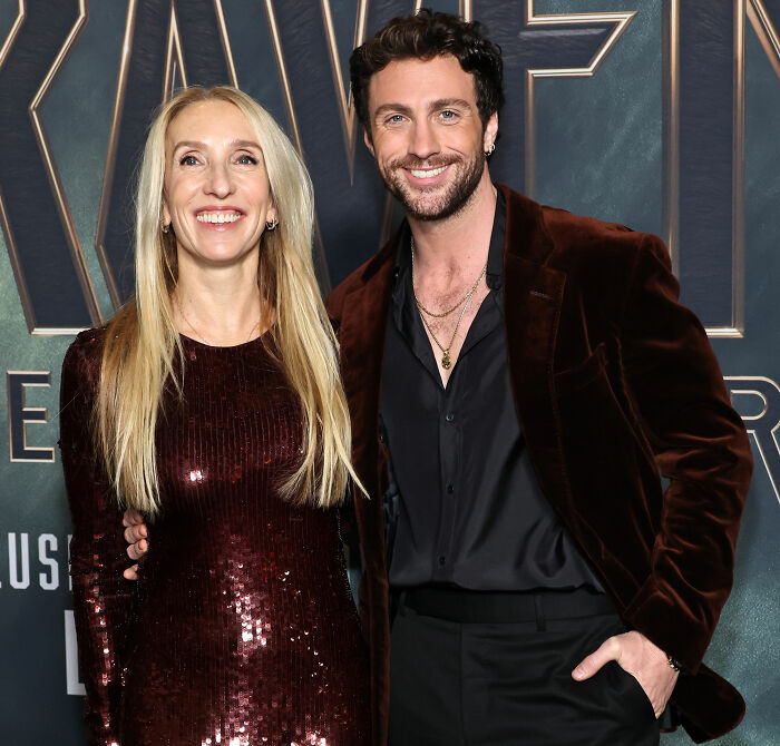 Aaron Taylor-Johnson and a woman posing at an event, highlighting fans’ comments on his evolved form appearance. Aaron Taylor-Johnson and a woman posing at an event, highlighting fans’ comments on his evolved form appearance.