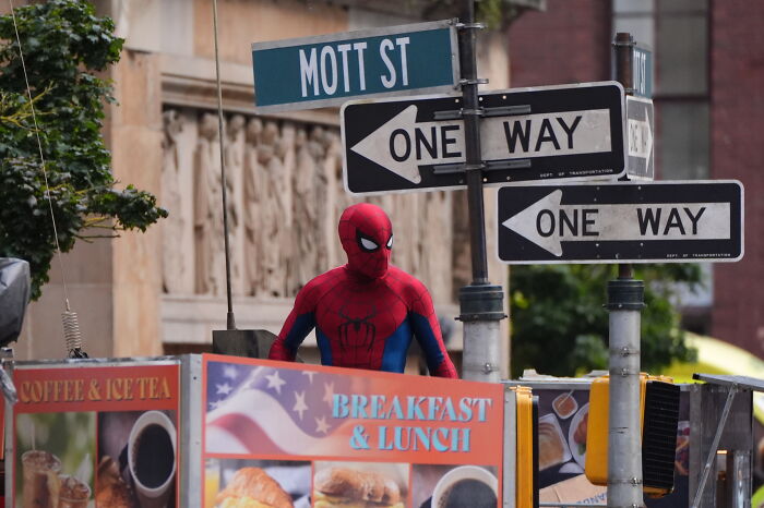 Spider-Man in costume near street signs during filming, sparking debate on controversial change to Tom Holland&rsquo;s web-slinger.