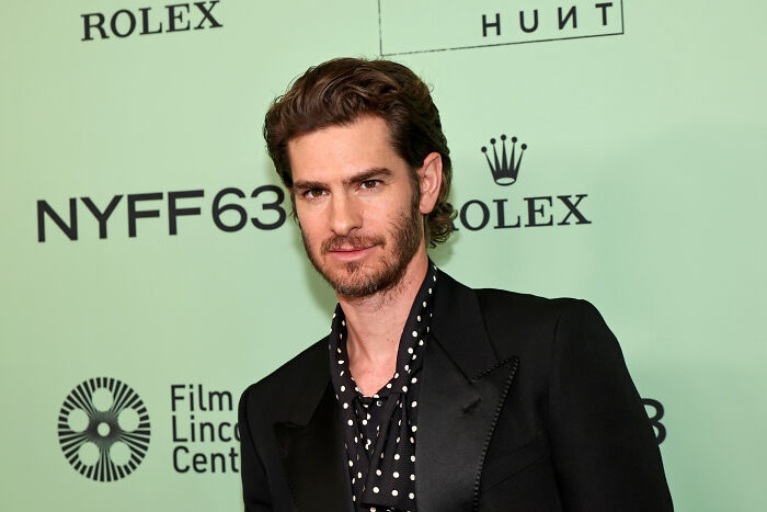 Andrew Garfield wearing a black suit with polka dot shirt at NYFF63 event, highlighting Harry Potter artists praised.