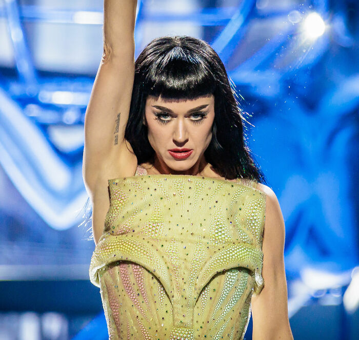 Katy Perry performing on stage with intense expression, highlighting the singer&rsquo;s grim response to struggling fan controversy.