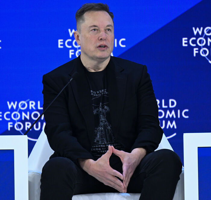 Elon Musk speaking at World Economic Forum event, with people noticing odd details inside his house.