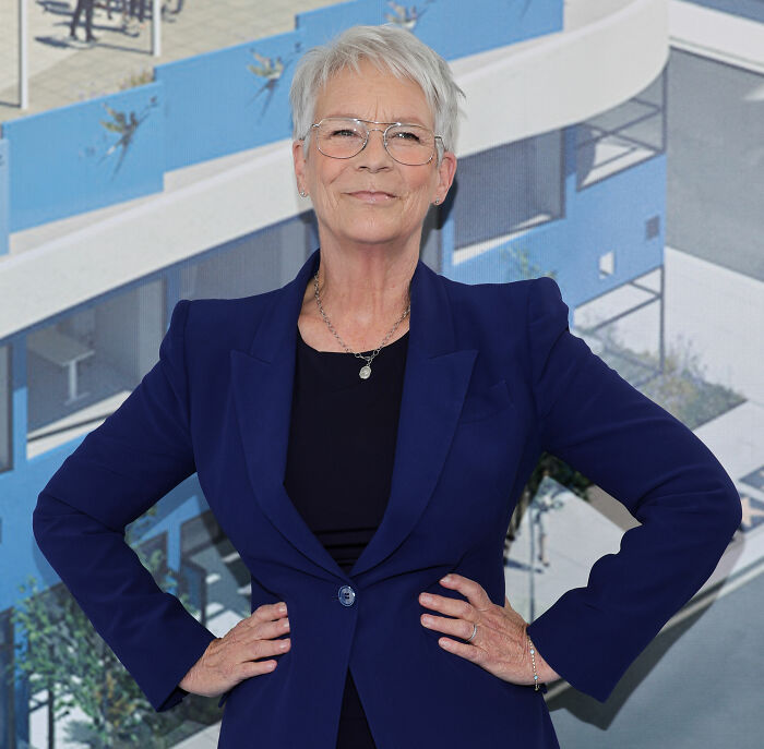 Jamie Lee Curtis posing confidently in a blue blazer with the White House backdrop related to diversity statement response.