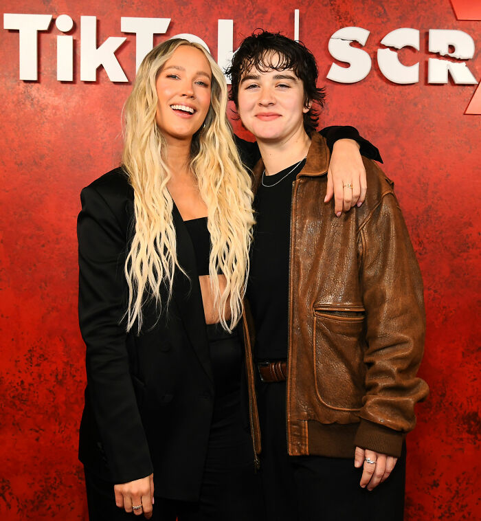 Anna Camp smiling with partner at TikTok event, highlighting her sexuality and age-gap romance confirmation.