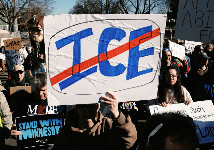 Protesters holding signs at a rally as the White House ruthlessly hits back at Jamie Lee Curtis diversity statement.